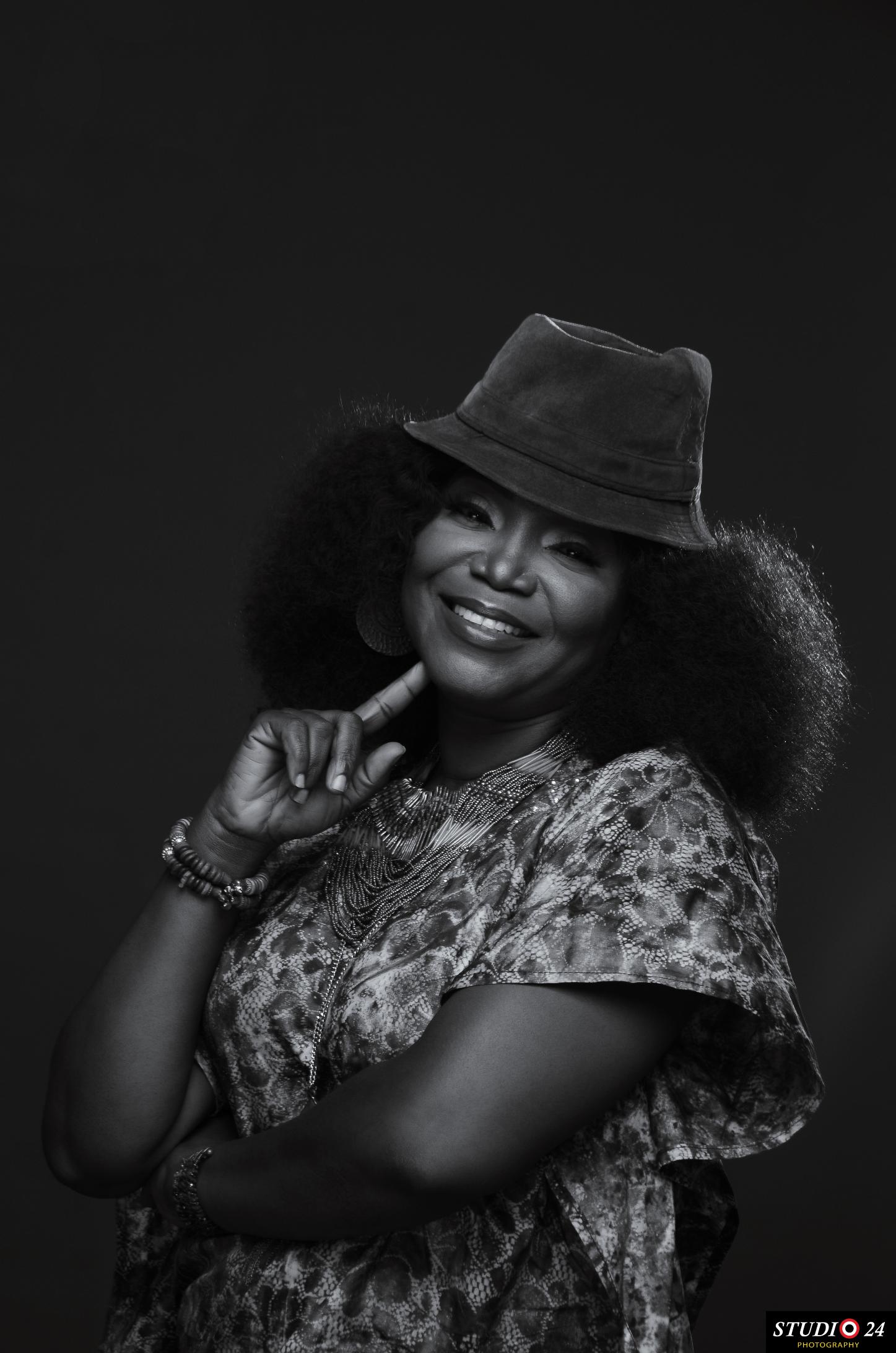 Black and white portrait of Temitope smiling in a hat